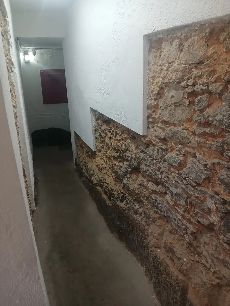 Trecho da muralha de pedra original da Fortaleza de São José exposta no túnel